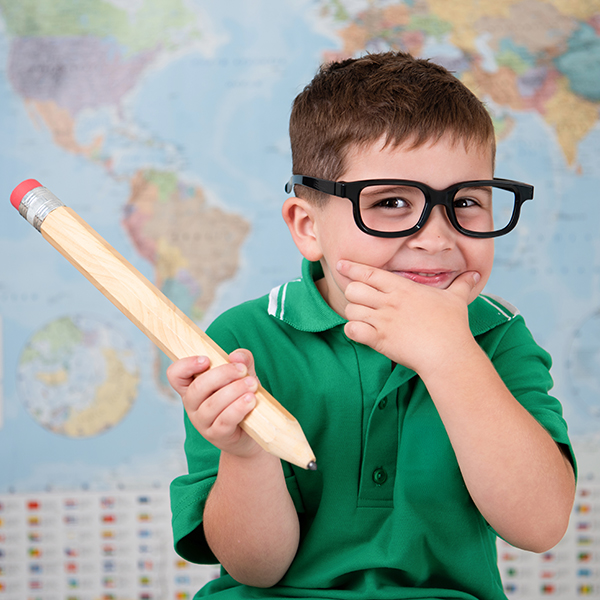 School Boy in uniform with glasses and pencil